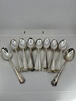 Front view of grouped spoons showing handle pattern and bowl condition