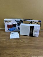 Radio with manual, power cord and box on tabletop