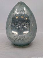 Front view of light blue speckled glass egg