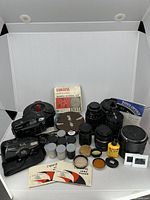 Full lot overview showing cameras, lenses, reels, filters, canisters, tape and accessories