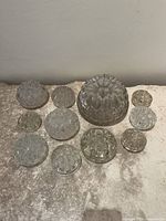 All eleven clear glass flower frogs displayed together