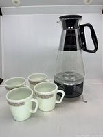Carafe on stand with four Pyrex mugs displayed