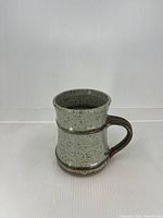 Front view of speckled stoneware mug showing glaze and form