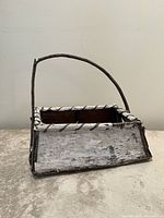 Front view of birch bark rectangular basket with twig handle