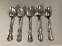 Front view of all five sterling silver teaspoons