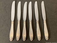 Six International Silver Prelude knives laid out side by side