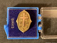 Front view of Birks shield pin in case