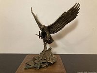 Full side view of bronze eagle sculpture on wood base