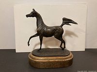 Full view of bronze horse sculpture on oak base