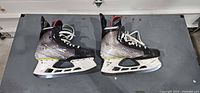 Pair of Bauer Vapor Hyperlite skates side view showing boots, holders, runners