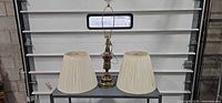 Full view of brass lamp with both pleated shades