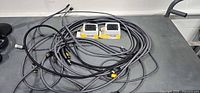 Group of braided HDMI cables and two boxed HDMI switch units on workbench