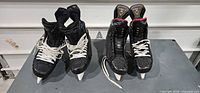 Front view of both pairs of hockey skates showing missing blades and overall wear
