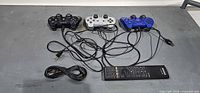 Overall lot showing three controllers, BD remote, and cables