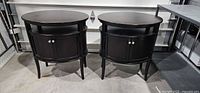 Two matching oval dark brown end tables side by side