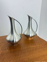 Front three-quarter view of both pewter vases on table