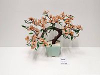 Full view of bonsai sculpture showing blossoms, leaves and pot