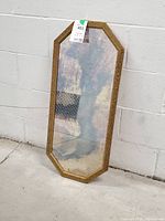 Full view of elongated octagonal mirror leaning against wall