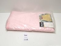 Full view of packaged pink bedspread with lot tag