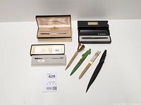 Group shot of four boxed pens and four letter openers