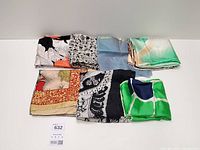 Seven folded silk scarves displayed together