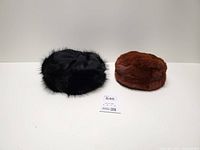 Black and brown fur hats side by side