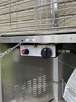 Close-up of control panel showing piezo igniter button, flame control knob and hose connection