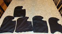 Five black balaclavas arranged on tabletop