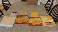 Overview of file folders and three sealed envelope packs on table