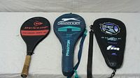 Three racket covers laid out: Dunlop, Slazenger, Shark