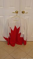 Front view of jersey showing large red maple leaf design