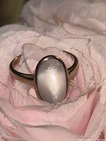 Front view of gold ring on fabric showing gemstone face