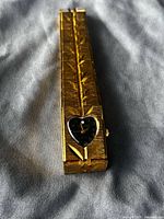 Front view of gold Geneva watch showing heart dial