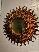 Full view of gold sunburst mirror on wall