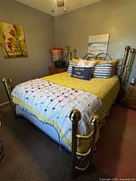 Full view of brass queen bed with bedding