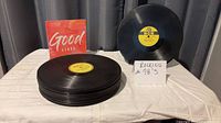 Stack of 78 RPM records, MGM record displayed, Good Vibes sleeve visible