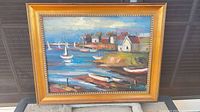 Full view of signed oil painting of harbor scene in gold frame