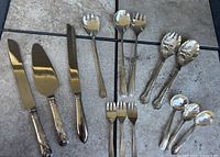 Complete group of 14 assorted serving utensils on tile background
