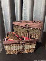 two stacked rattan baskets with liners and scarves visible