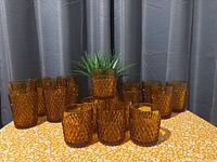 Full set of amber diamond-cut glasses displayed on table