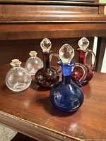 Five glass bottles grouped on table