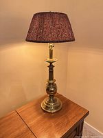 Brass table lamp with shade on wooden table