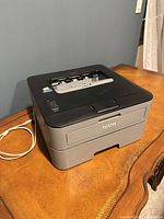 Brother HL-2300D printer on desk with USB cable attached