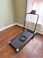 side view of folded treadmill with cable on belt