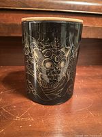 Front view of black ceramic canister showing cat graphic design