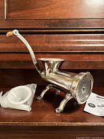 side view of stainless steel manual meat grinder with stuffing tube and manual