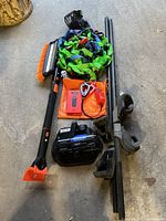 Group shot of all items: snow brush, roof rack bars, tie-downs, air compressor, jump starter