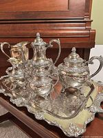 Full view of six silver-plate pieces on tray