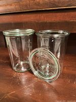 Two clear Weck jars with one lid off to show opening