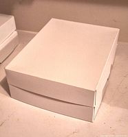 Closed white cardboard box of label sheets